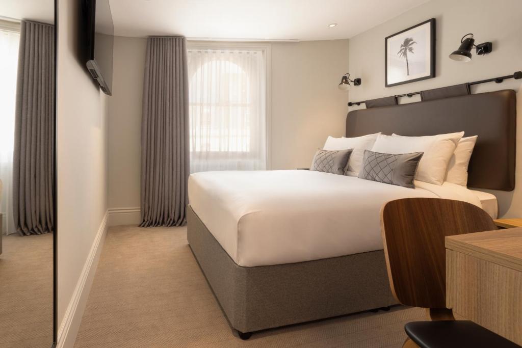 a bedroom with a large bed and a window at The 55 by Le Mirage in London