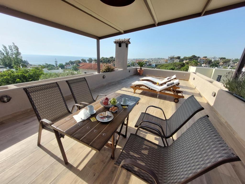 un patio con tavolo e sedie sul balcone. di SEA VIEW APARTMENT 15 MIN FROM ATHENS AIRPORT a Nea Makri