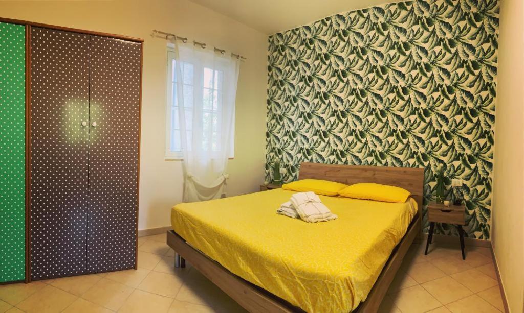 een slaapkamer met een bed met gele lakens en een raam bij CASINA DAMÍ in Canosa Sannita