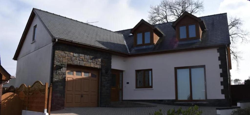 a white house with a garage at Captivating 4-Bed House in west Wales in Pencader