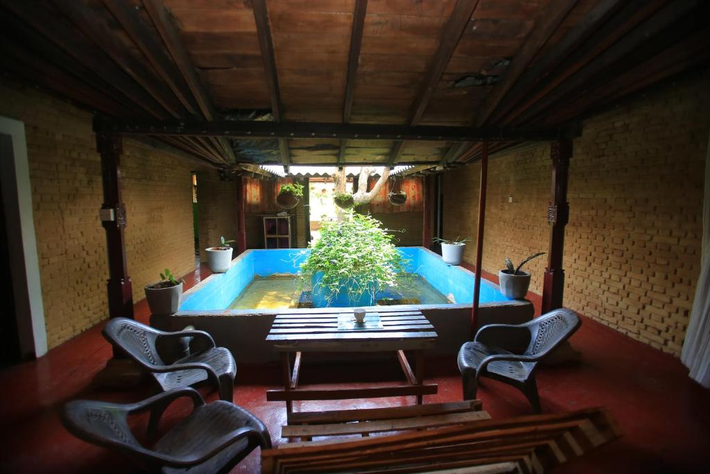 a room with a pool with two chairs and a table at Sigiri Peace Hostel in Sigiriya