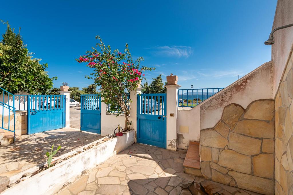 une porte menant à une maison avec des portes bleues dans l'établissement Casa Vacanze 21 Aprile - 1, à Calasetta