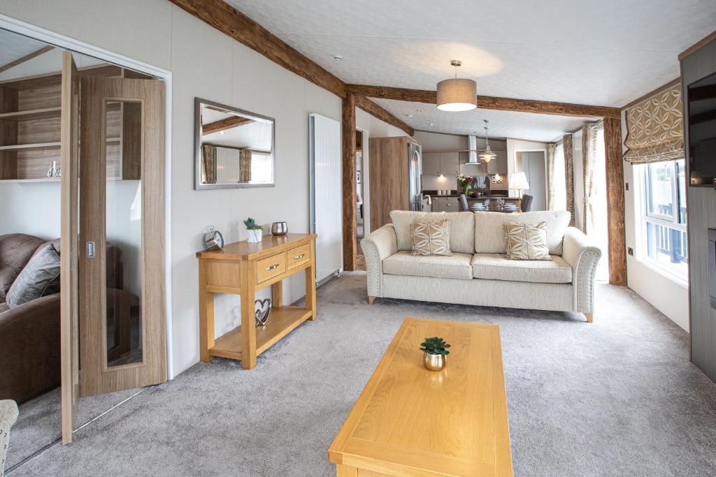 a living room with a couch and a table at Stewarts Resort Lodge 8 in St. Andrews