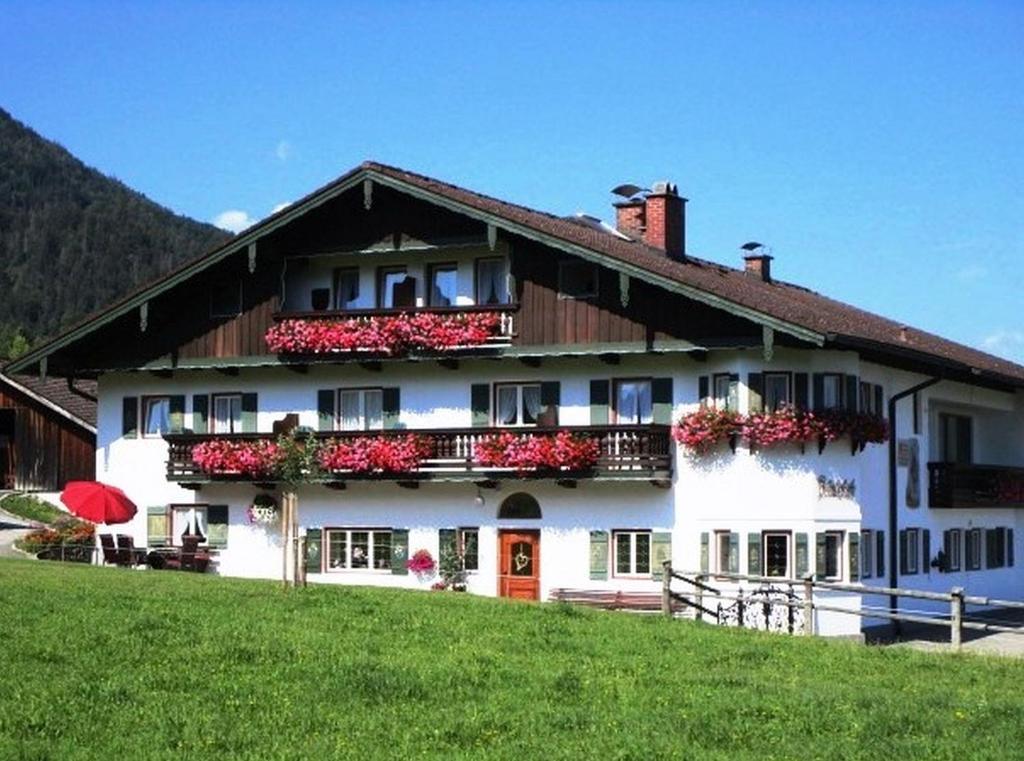 a large white house with flowers on the balcony at Bräulerhof in Bayerisch Gmain