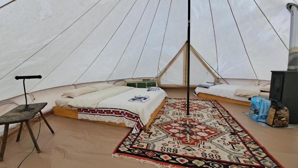 - une chambre avec 2 lits et un tapis dans une tente dans l'établissement Dolina Village Glamping, à Zece Hotare