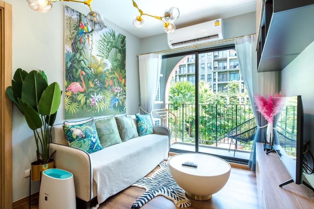 a living room with a couch and a large window at 2BR Designer's villa at Cicada Huahin in Hua Hin