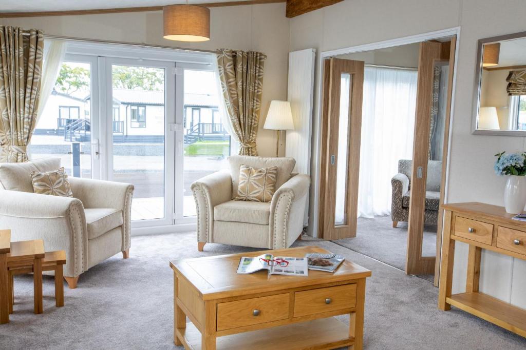 een woonkamer met 2 stoelen en een salontafel bij Stewarts Resort Lodge 7 in St Andrews