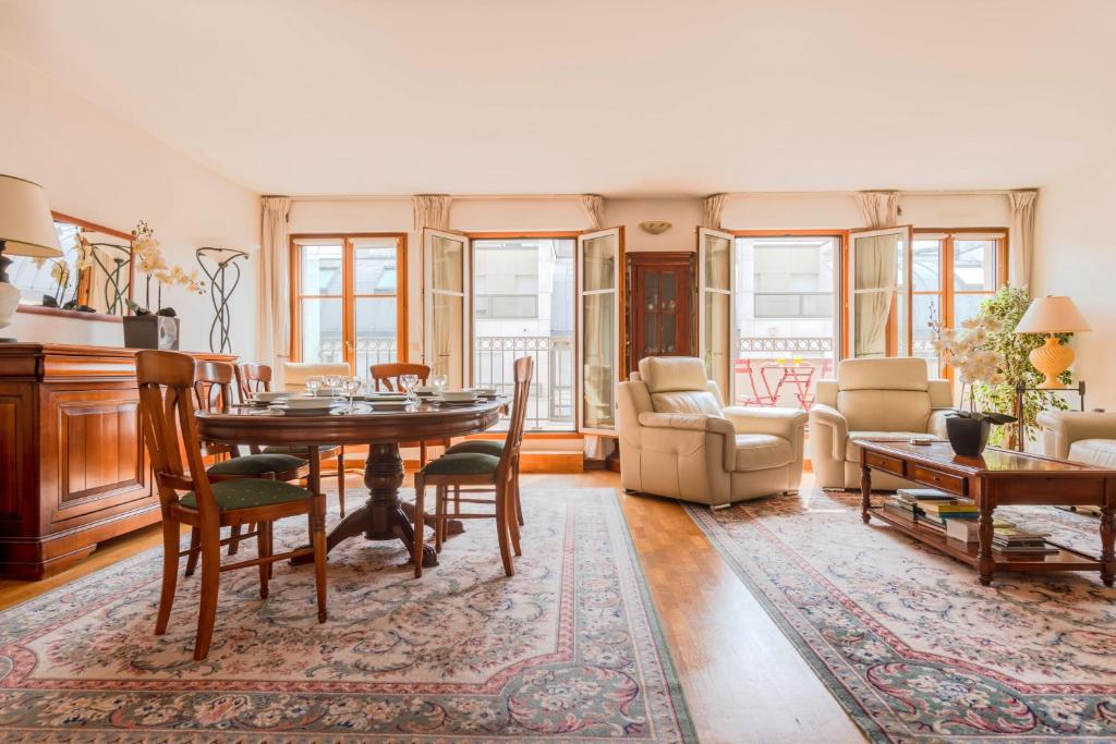 - un salon avec une table et des chaises dans l'établissement Beaudelaire Center Residence, à Paris