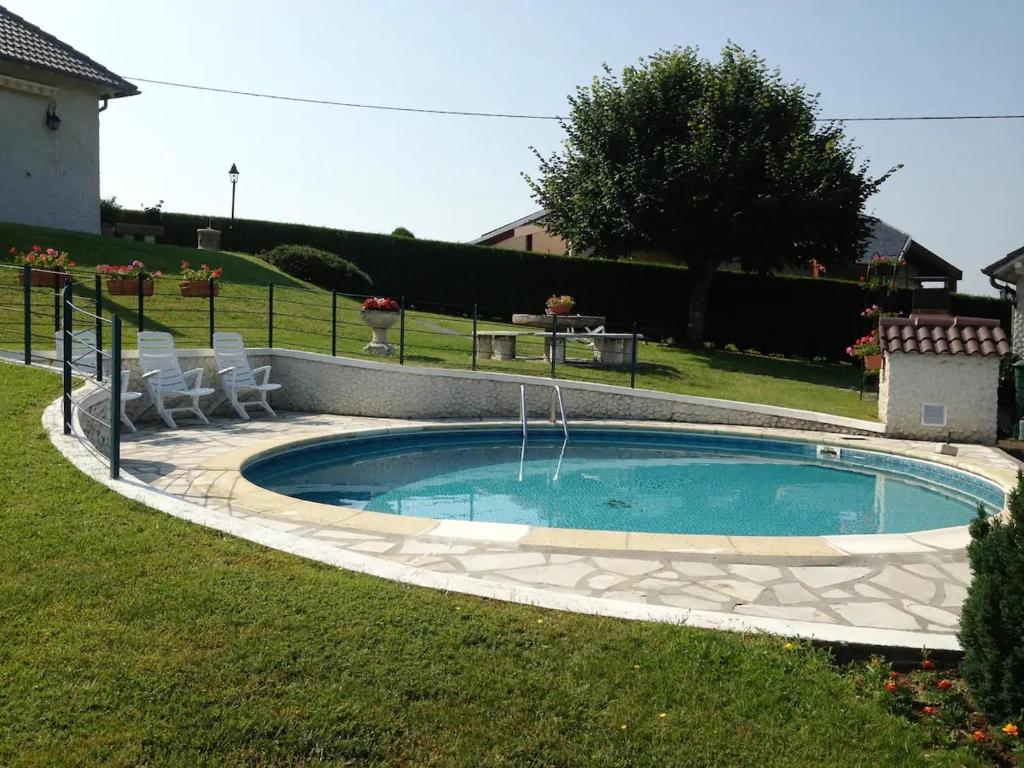 een zwembad in een tuin met stoelen eromheen bij Villa Pougeol - Charmante Villa Calme & Paisible - Avec Piscine & Terrain de Pétanque in Chanac-les-Mines