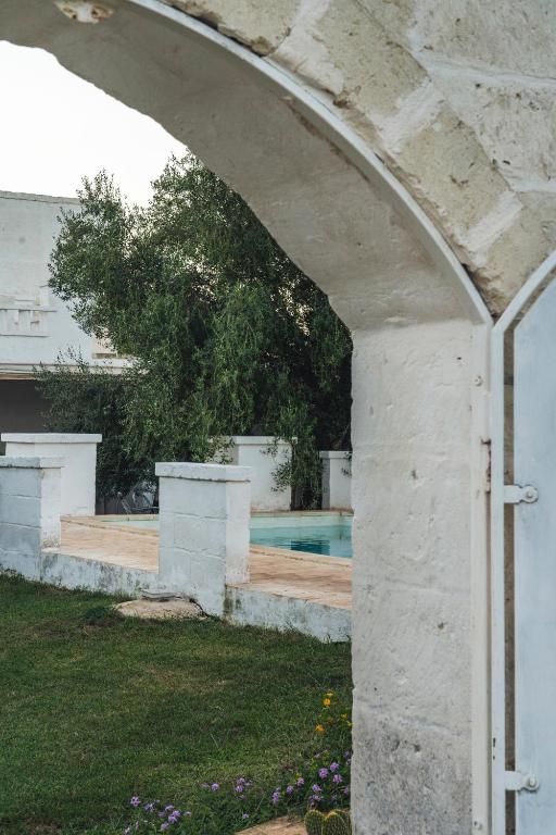 an archway over a yard with a swimming pool at Masseria della Piana in Villanova di Ostuni