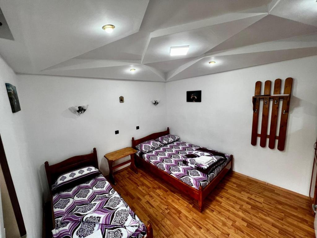 twee bedden in een kamer met houten vloeren bij CASA CU LAVANDĂ in Vatra Dornei