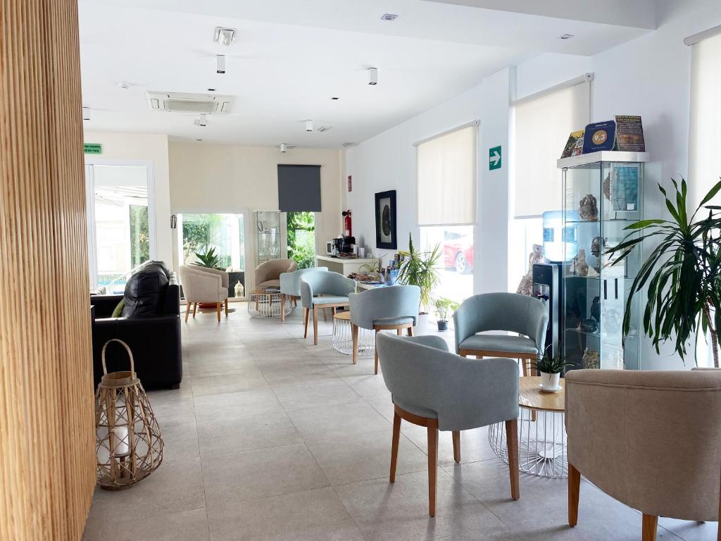 a waiting room with chairs and tables in a building at Hotel Senderos in Agua Amarga