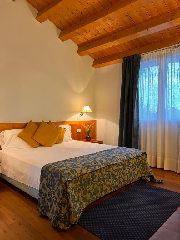 a bedroom with a bed and a large window at Hotel Due Torri Tempesta in Noale
