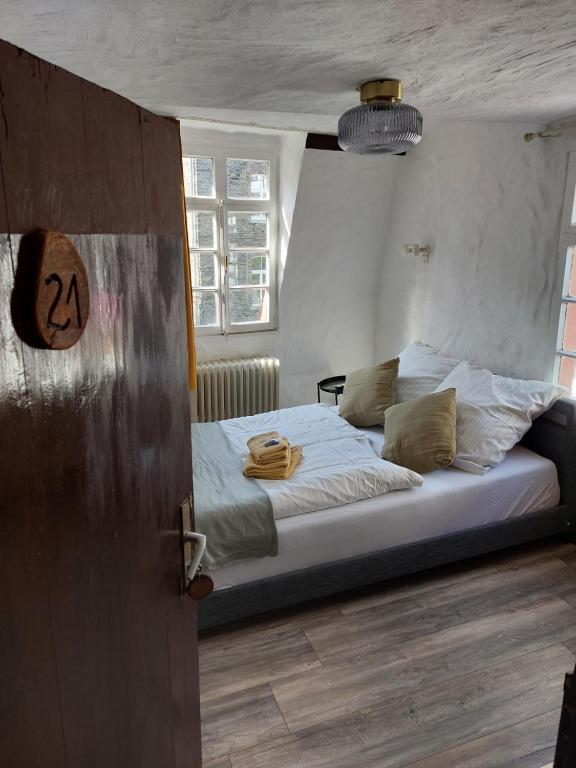 um quarto com uma cama grande e lençóis brancos em ReSt Inn Monschau em Monschau