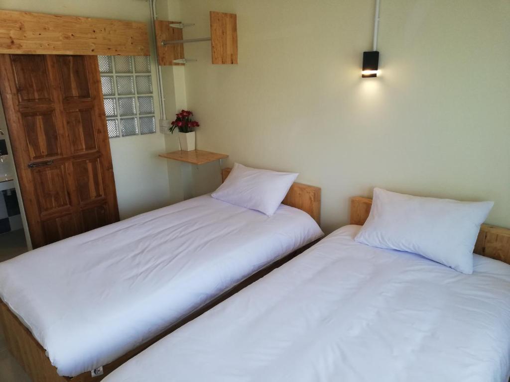 duas camas sentadas uma ao lado da outra num quarto em HILLDA HOUSE em Chiang Mai