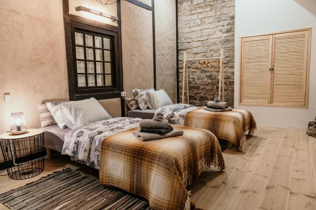 a bedroom with two beds and a brick wall at Narva Castle Rooms in Narva
