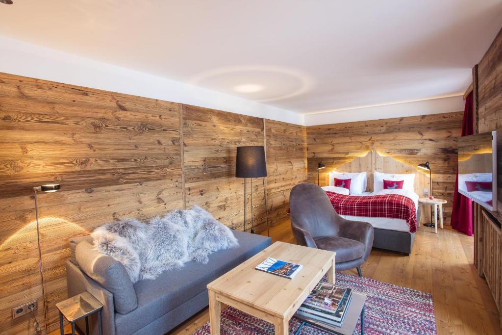 a living room with a couch and a bed at Kitzhof Mountain Design Resort in Kitzbühel