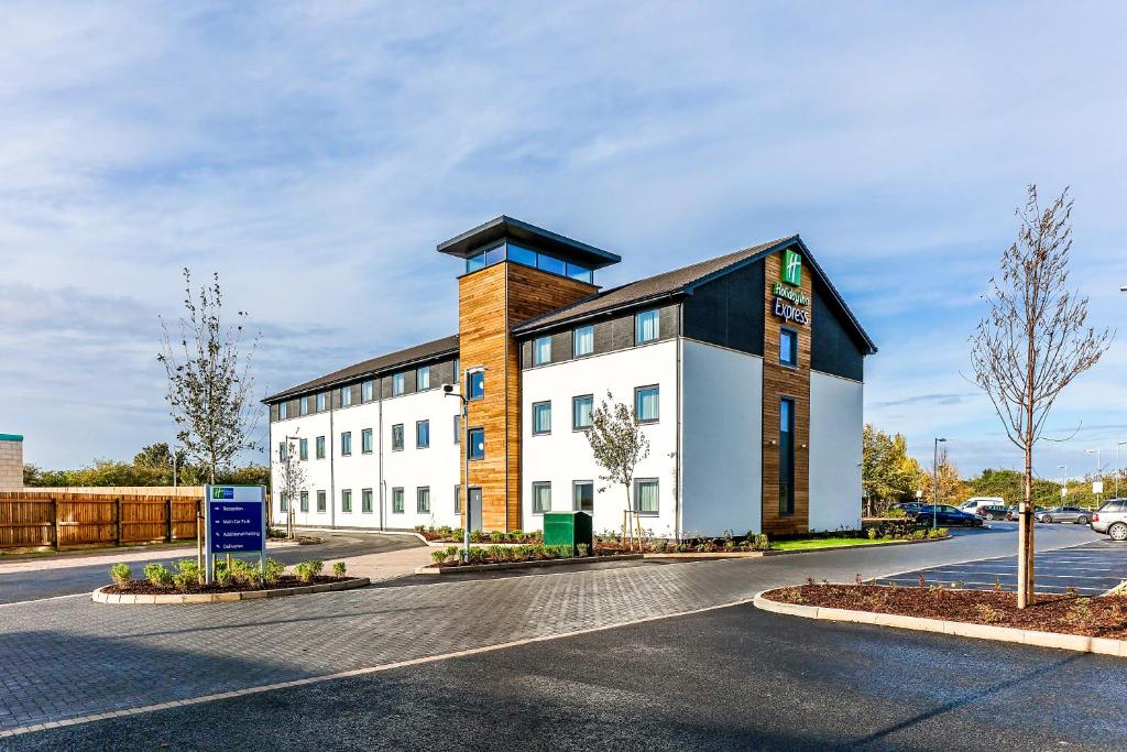 un grand bâtiment blanc avec un toit noir dans l'établissement Holiday Inn Express Cambridge, an IHG Hotel, à Cambridge