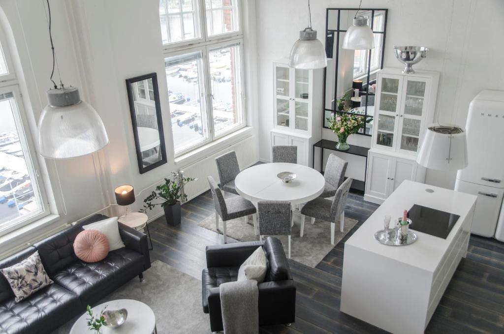 a living room with a couch and a table and chairs at Upea loftsuite, järvinäkymä, wifi, sauna & spa in Tampere