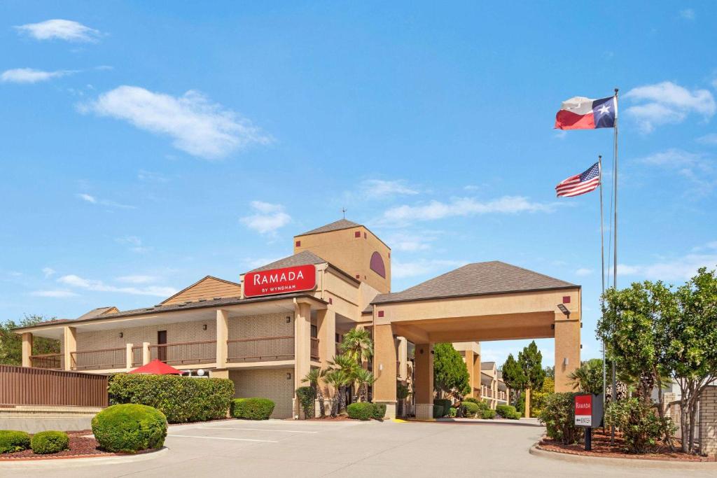 una señal para un hotel con bandera americana en Ramada by Wyndham San Antonio Near SeaWorld - Lackland AFB, en San Antonio