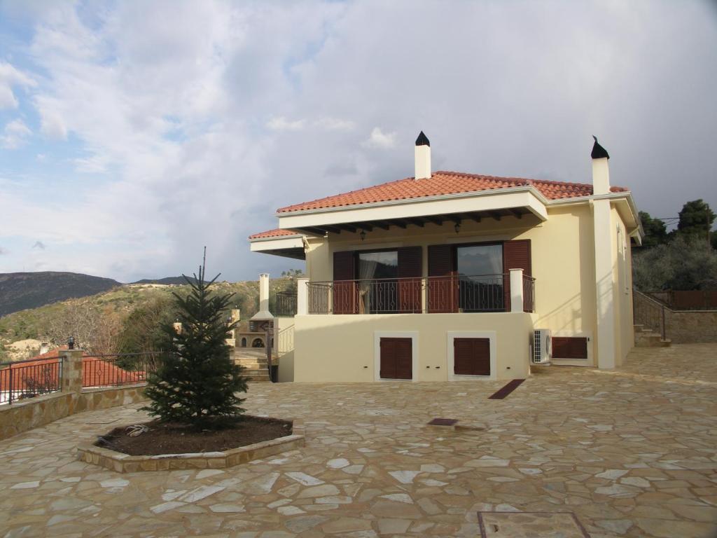 a house with a christmas tree in front of it at Kallisti Ξενώνας Διακοπτό-Καλάβρυτα in Diakopto