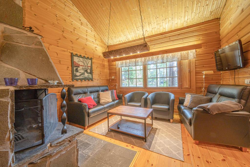 レヴィにあるLevillas Lomakoto 1の革製の家具と暖炉のあるリビングルーム