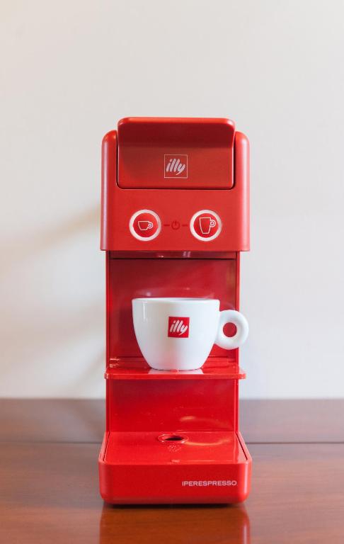 a red espresso machine with a cup on top at Hotel & Restaurant Pahor in Doberdò del Lago
