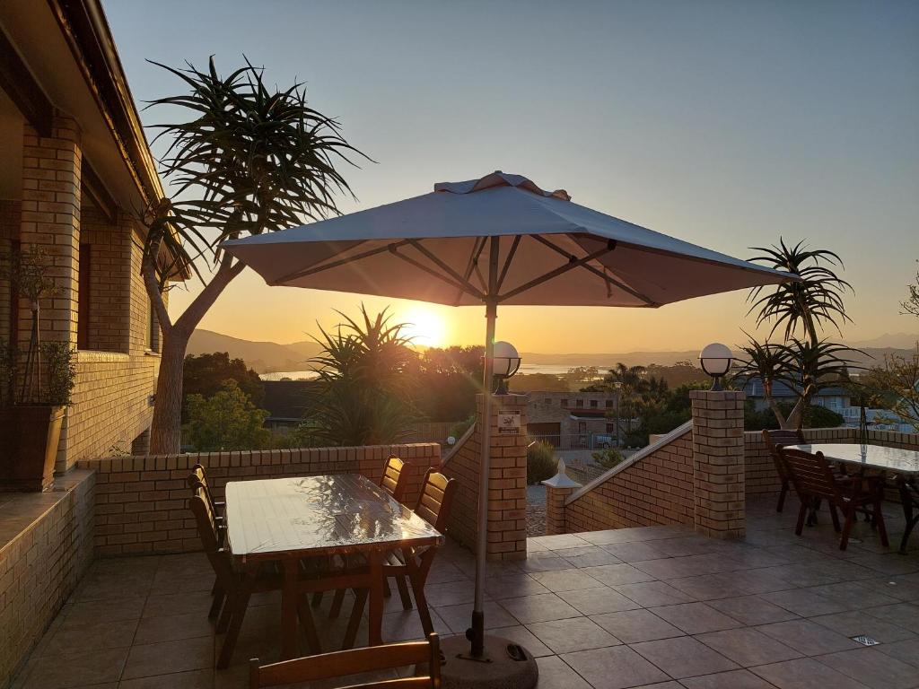 a table with an umbrella on a patio at Amber Guest Lodge in Knysna