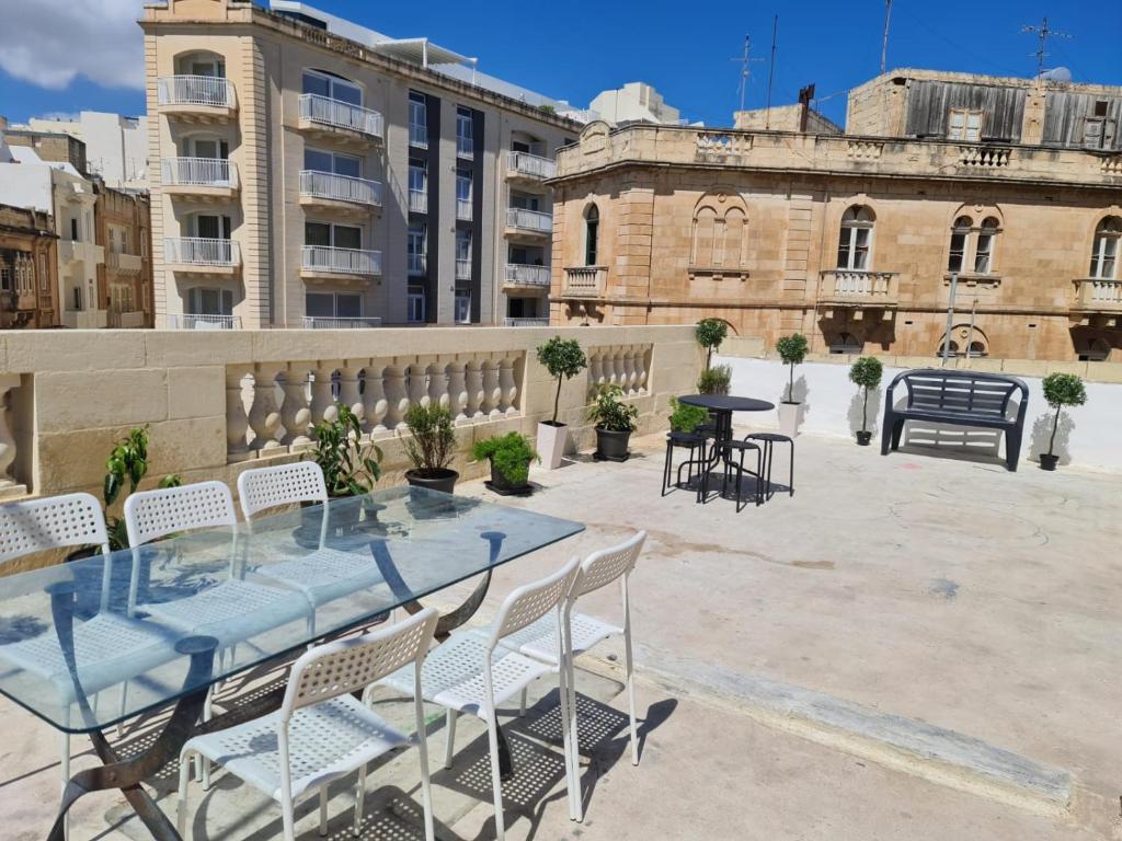 a patio with a table and chairs and a building at Hostel On in Sliema