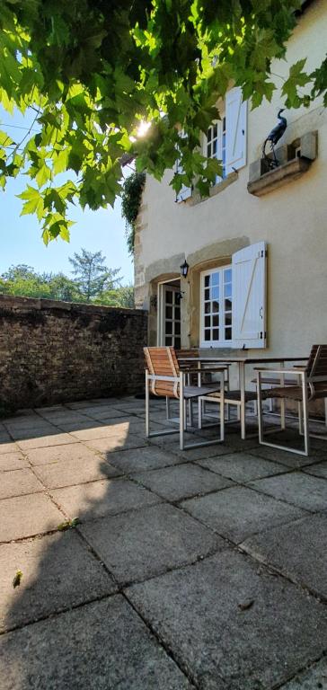 a table and two chairs in front of a building at Le Fier Paon in Pierrefaites