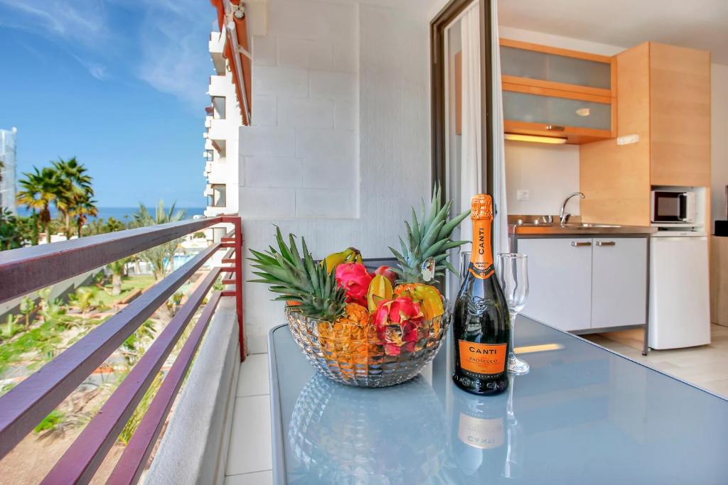 eine Flasche Wein auf einem Tisch mit einem Obstkorb in der Unterkunft ON THE BEACH, Sea View, Fast Fiber, Pool, Parking in Playa de las Americas