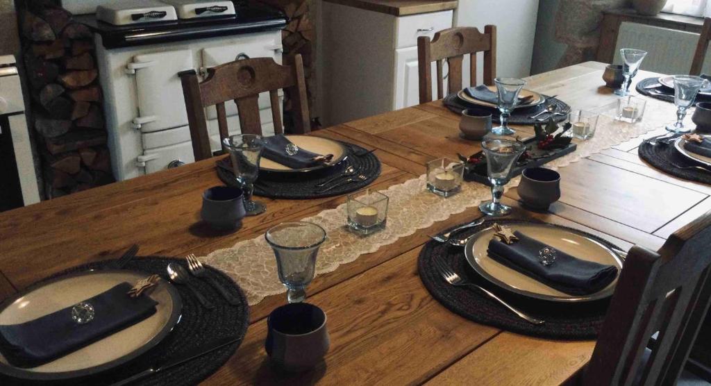 uma mesa de madeira com pratos e guardanapos em cima em Tiny Acorns chambre d’hôte em Darnac
