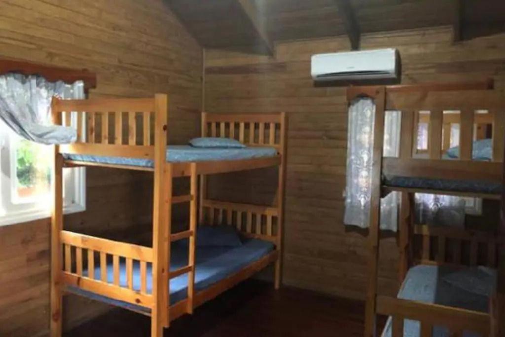 a room with three bunk beds in a cabin at La Cabaña de Andre in Nimá