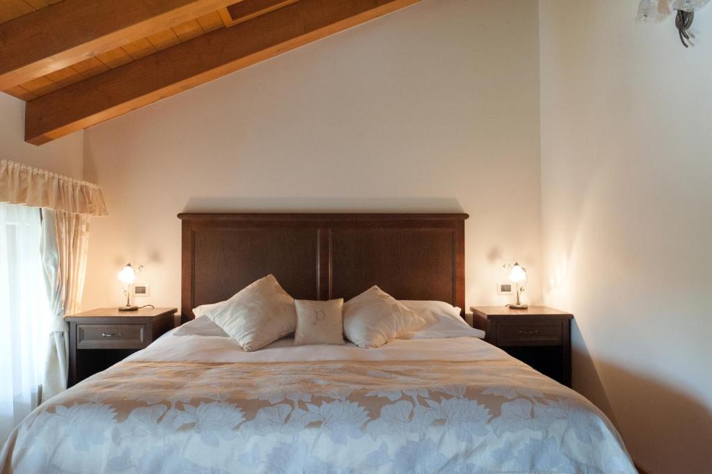 a bedroom with a large bed with two night stands at Hotel & Restaurant Pahor in Doberdò del Lago