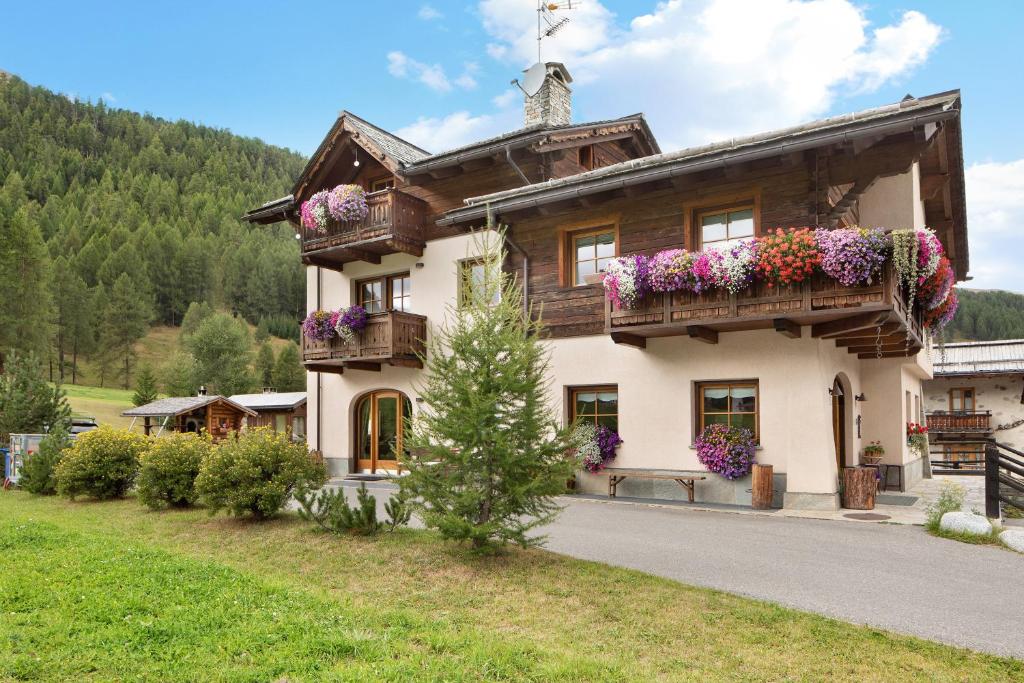 a large house with flowers on the balconies at Terra Chalet Martina in Livigno