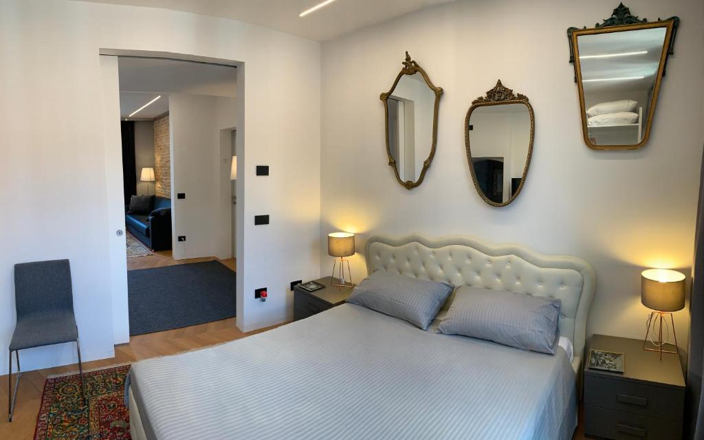 a bedroom with a bed and mirrors on the wall at Suite Falier- Luminosa Venezia in Venice