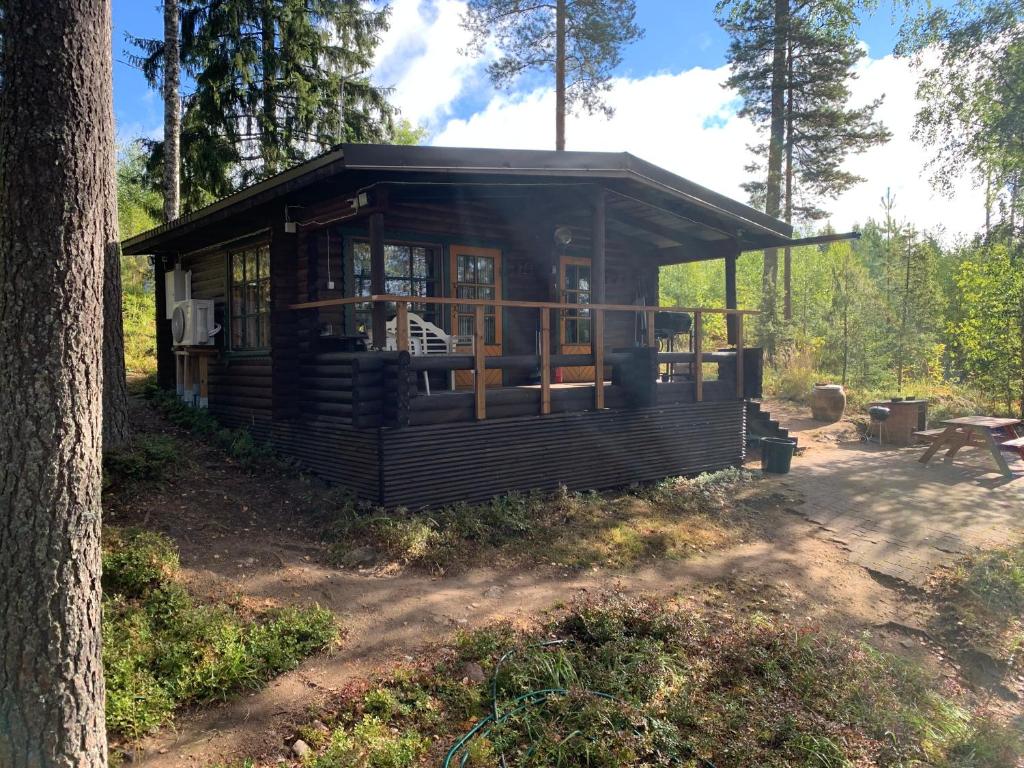 una pequeña cabaña en el bosque con un árbol en Kesämökki Kalliola Heinola, en Ahvenisto