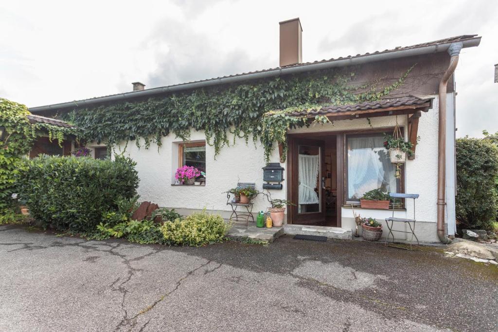 a white house with ivy on the side of it at Haus Rosi und Werner in Emmerting