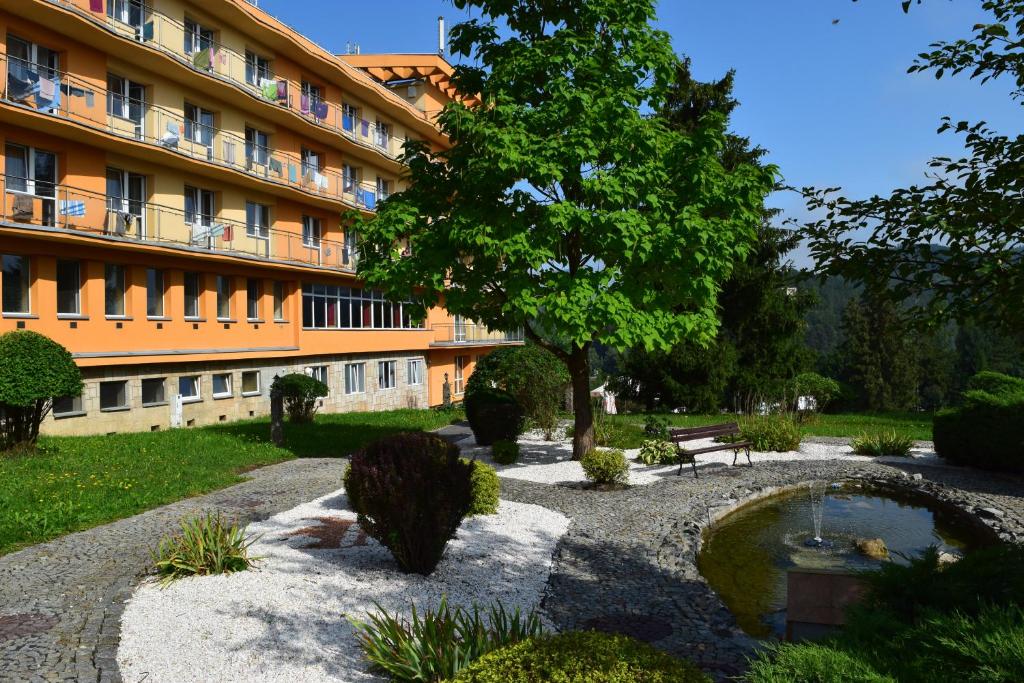 a building with a pond in front of a building at KORONA Sanatorium Uzdrowiskowe in Muszyna