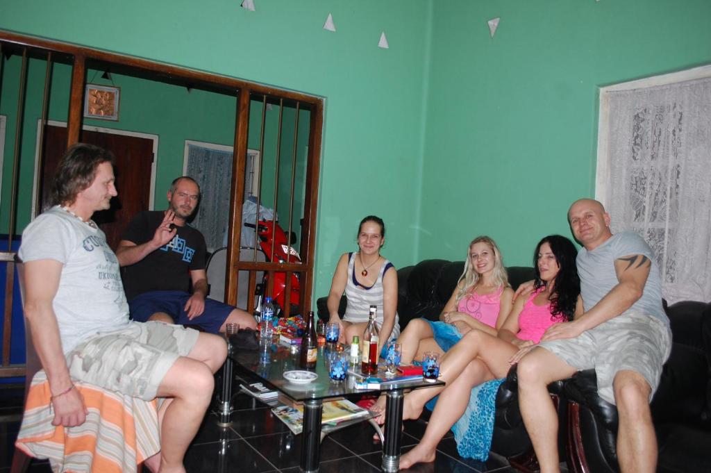 um grupo de pessoas sentadas num sofá em Udara's Colombo Rooms em Battaramulla