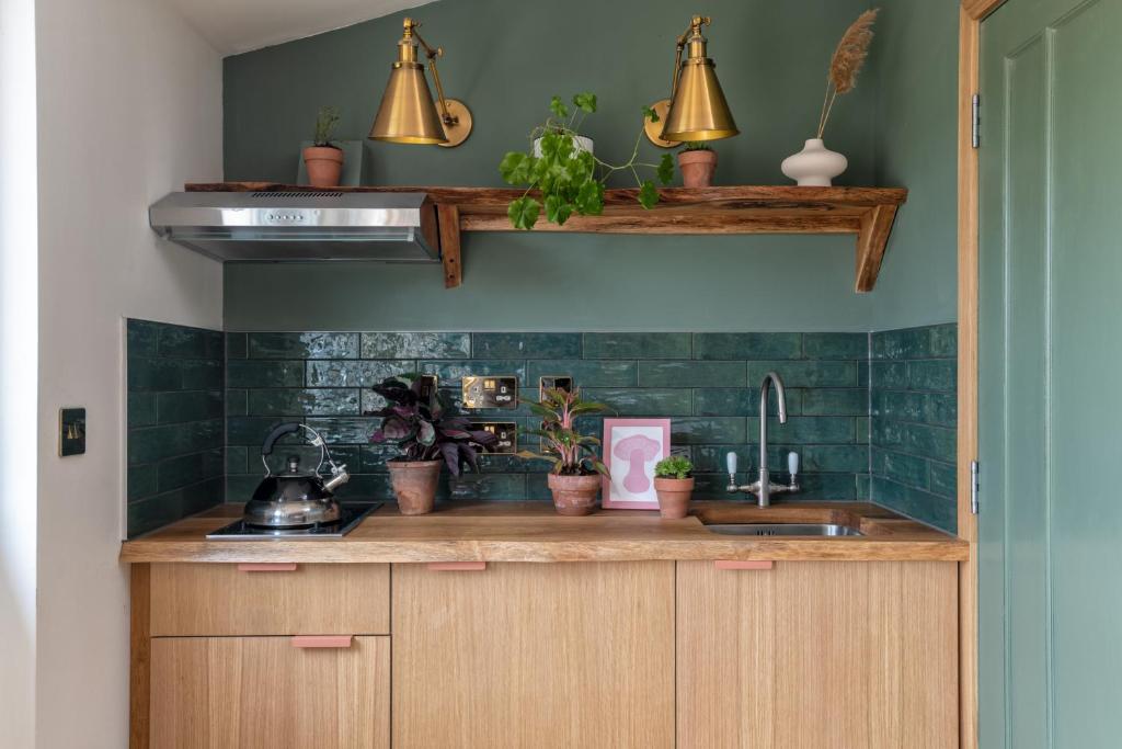 a kitchen with green tiled walls and a sink at Charming boutique forest view cabin with hot tub in Ballater in Ballater