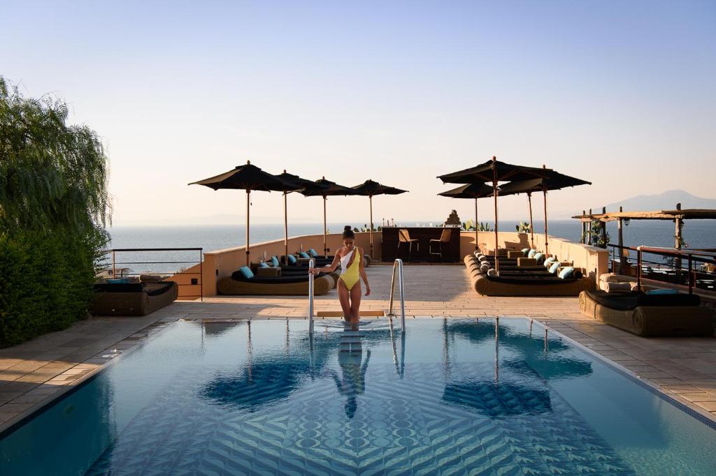 una mujer parada en una piscina en un hotel en Villa Marina Capri Hotel & Spa, en Capri