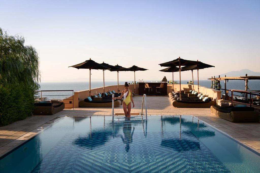 une femme debout dans une piscine d'un hôtel dans l'établissement Villa Marina Capri Hotel & Spa, à Capri