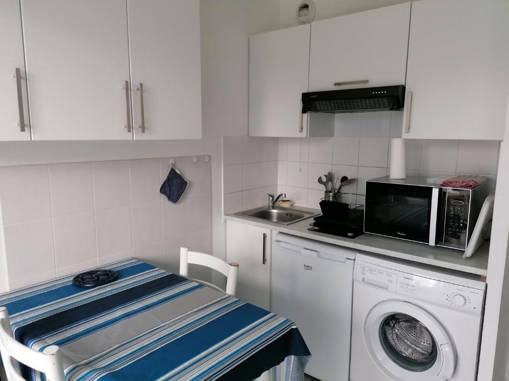 uma cozinha com uma máquina de lavar roupa e um micro-ondas em Gaindeguia Studio em Cambo-les-Bains