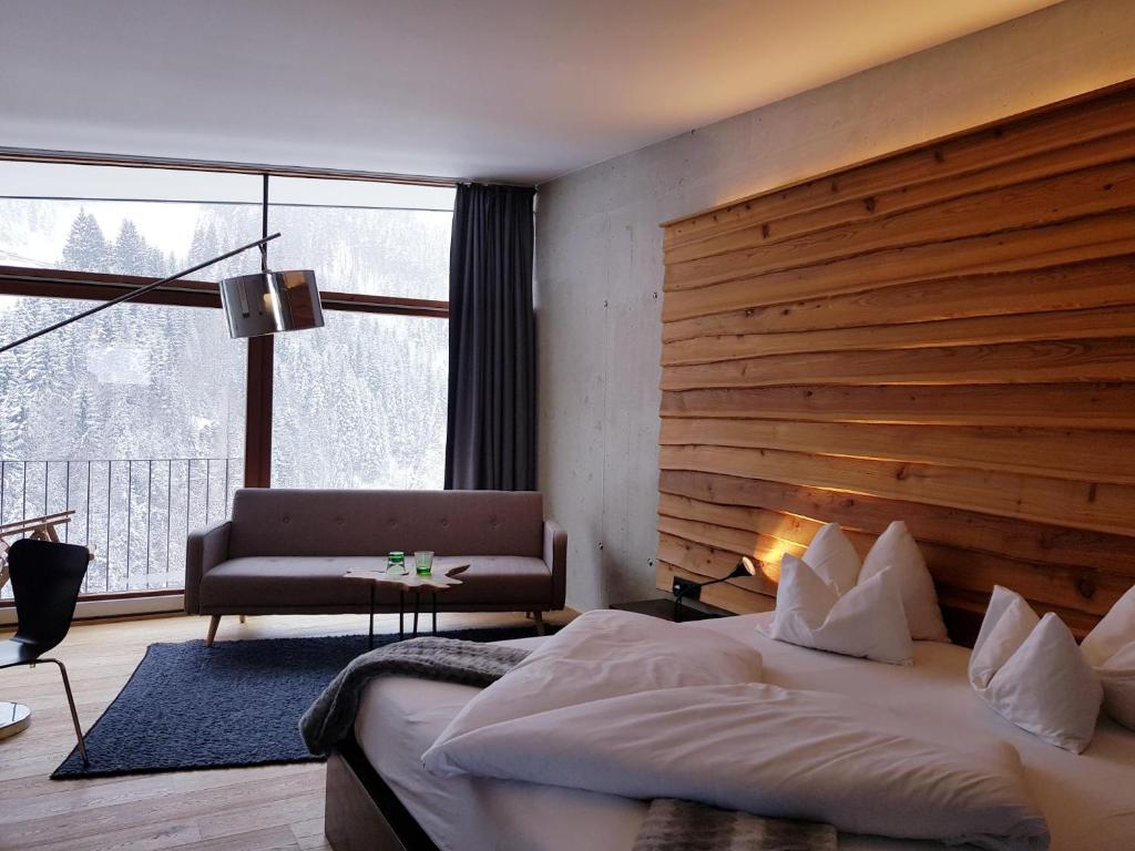 ザンクト・アントン・アム・アールベルクにある"Quality Hosts Arlberg" Hotel Lux Alpinaeのベッドルーム(大型ベッド1台、大きな窓付)