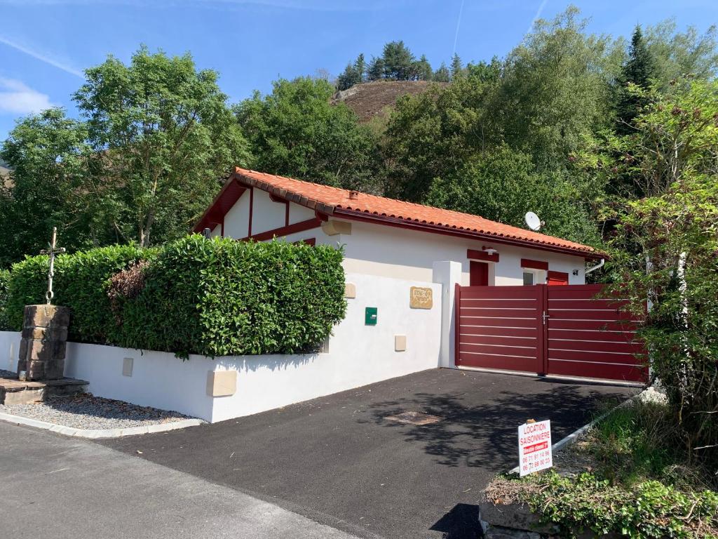 a house with a red fence and a driveway at Villa 2 étoiles Etxe Xumea in Aldudes