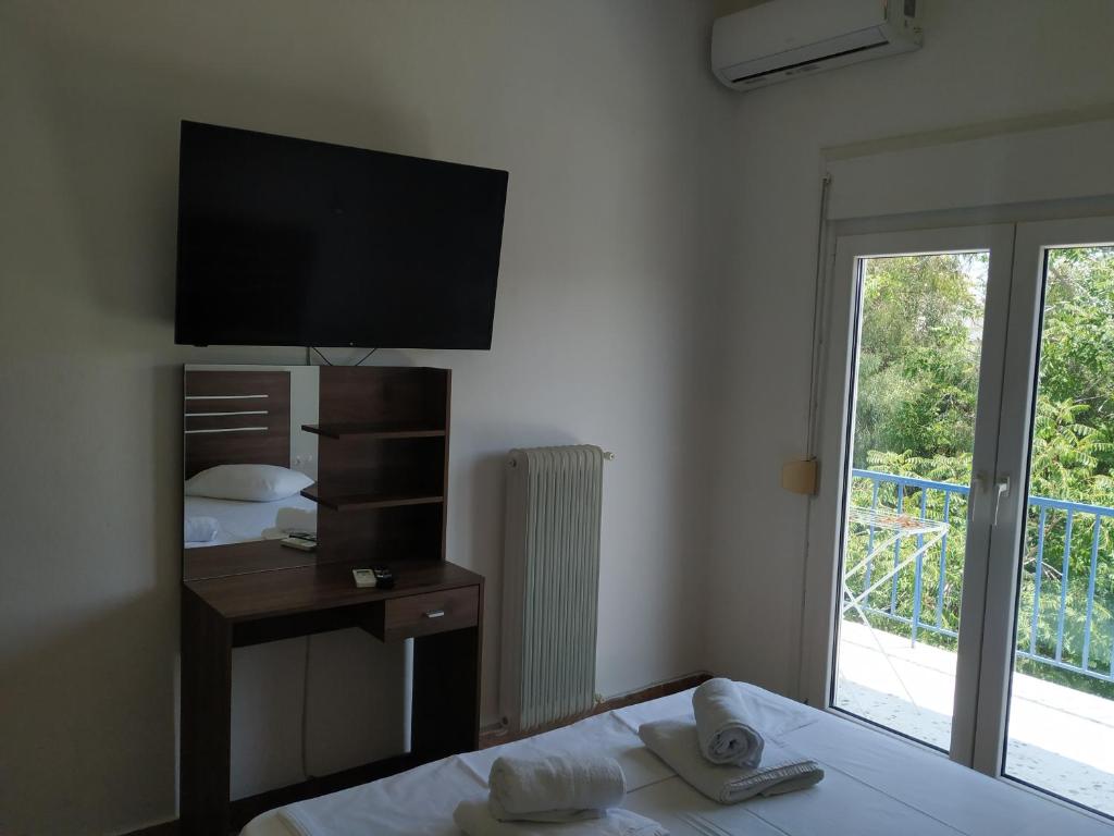 1 dormitorio con cama, espejo y ventana en Market, en Korinthos