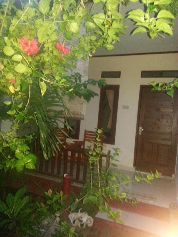 Cette chambre offre une vue sur une maison dotée d'une véranda fleurie. dans l'établissement Family bungalow, à Gili Meno
