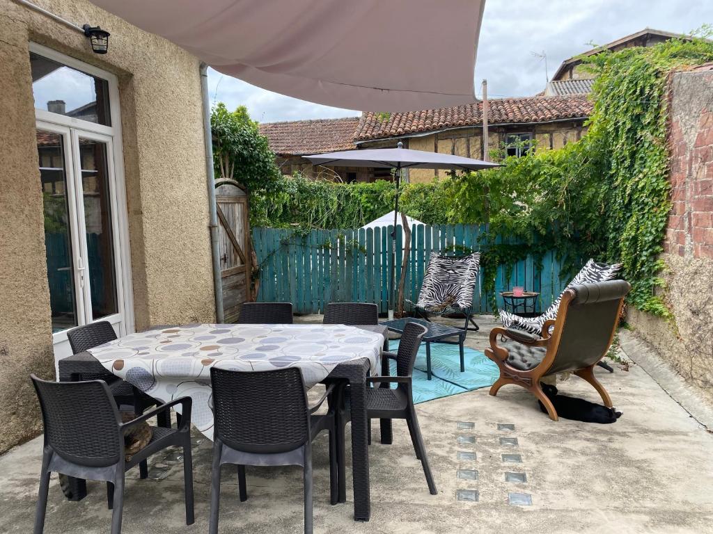 a patio with a table and chairs and a fence at Petit paradis in Vic-Fezensac