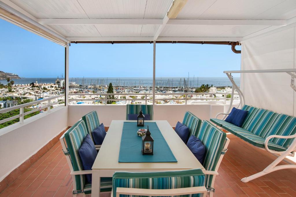 a table and chairs on a balcony with a view of the ocean at Casa Luis Montesdeoca in Puerto de Mogán